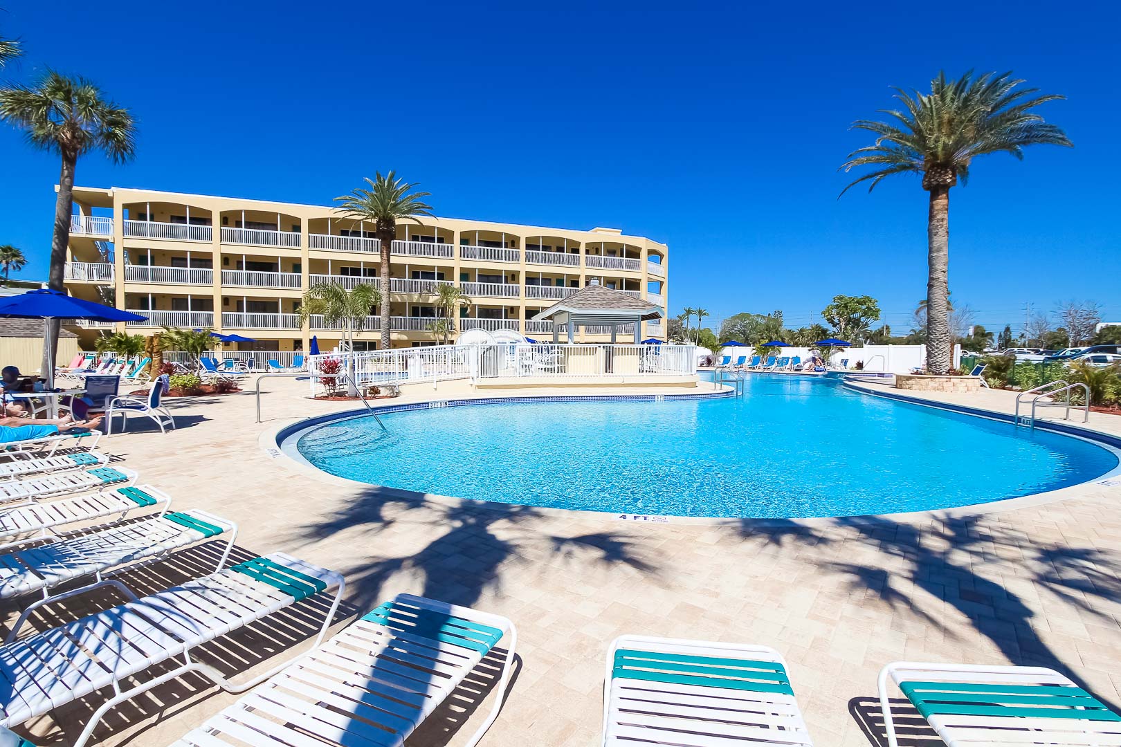 A relaxing view of the outdoor swimming pool at VRI's Coral Reef Beach Resort in St. Pete Beach, Florida.